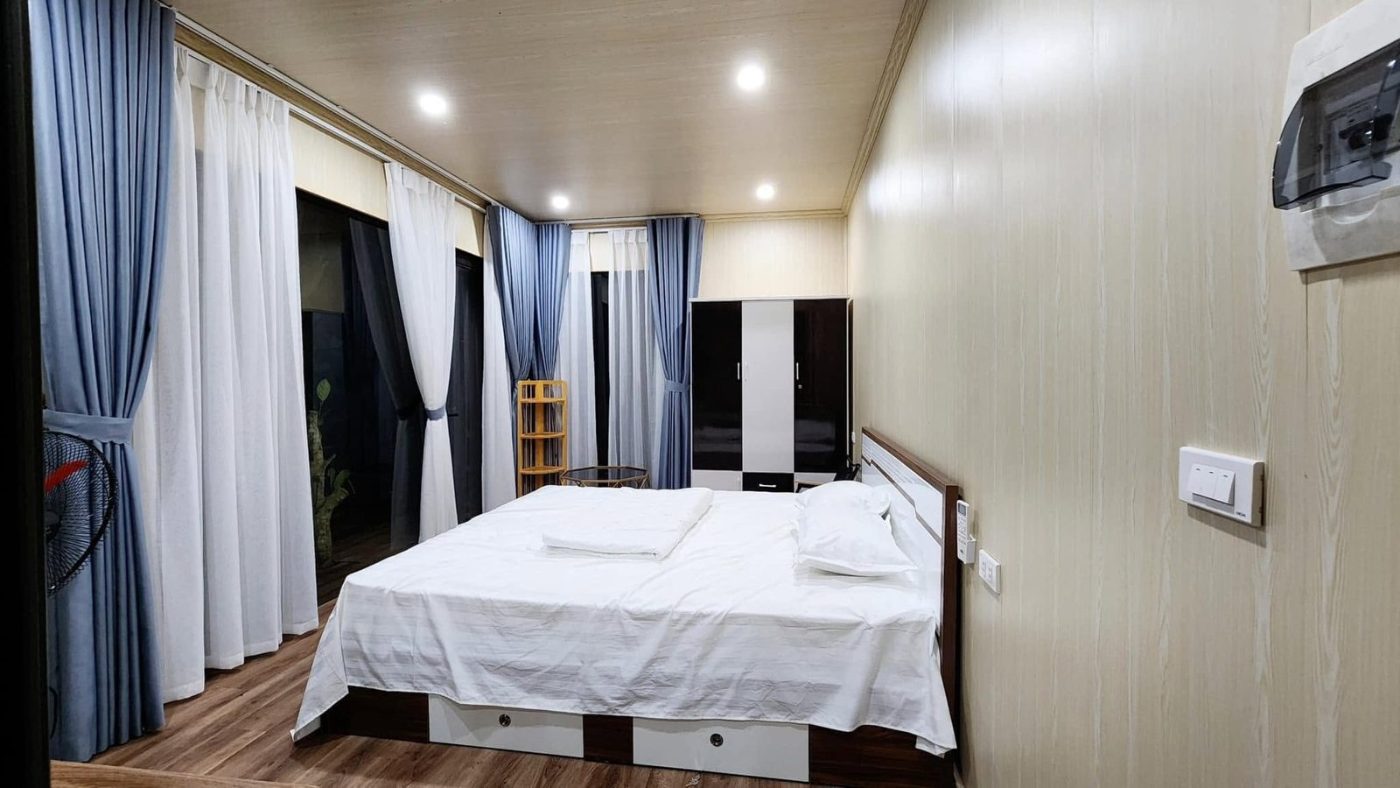 Phòng ngủ sáng sủa với giường đôi và rèm xanh